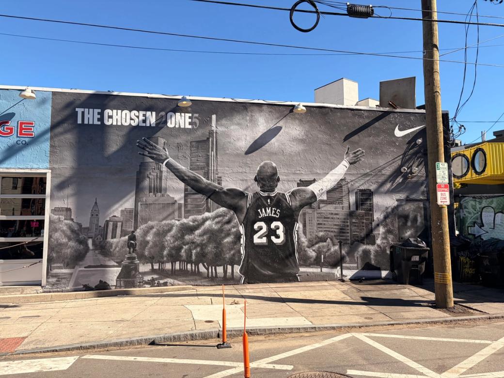 A mural of LeBron James on the Garage bar in Fishtown. The black-and-white mural shows James’ back with his arms raised and he’s staging at Philly. In the upper left corner reads “THE CHOSEN 2ONE5” and the Nike brand “swoosh” logo is in the upper right corner.