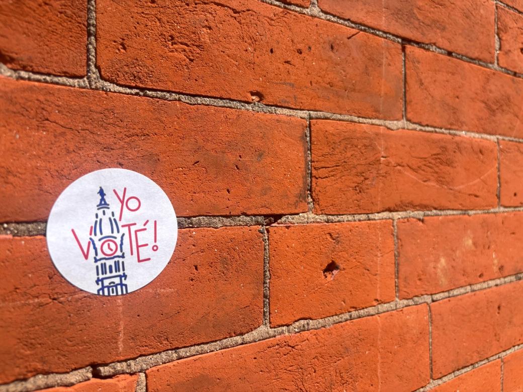 A "Yo voté!" sticker on a brick wall