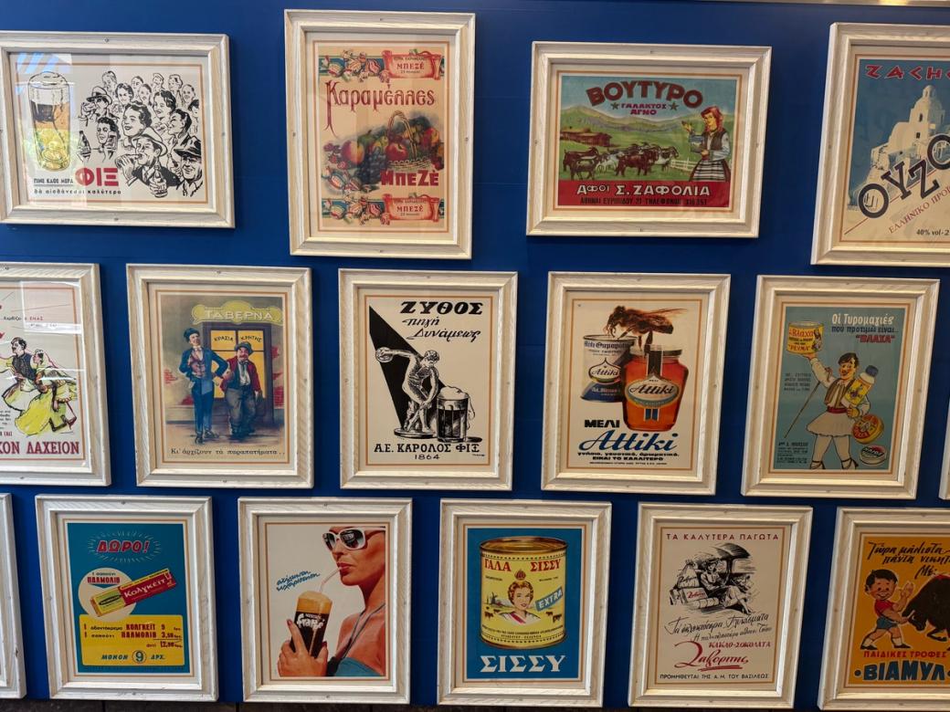 A series of framed advertisements on a blue wall.