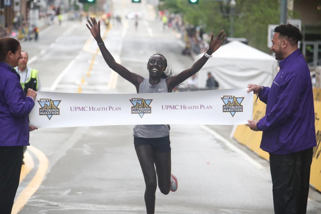 runner crossing the finish line at Pittsburgh Marathon