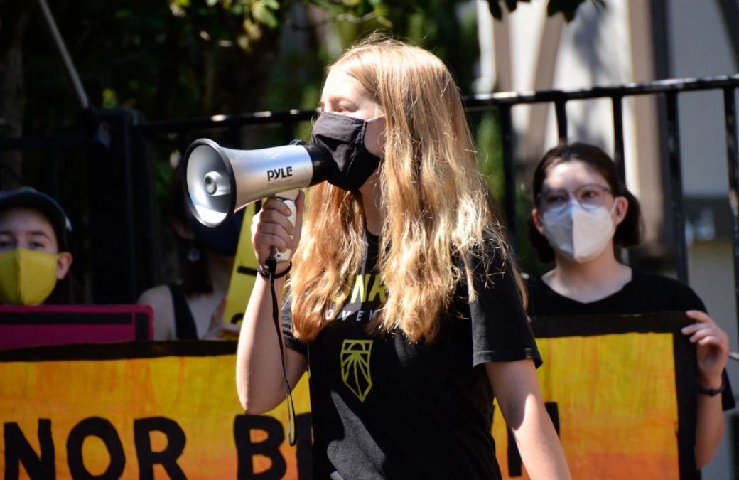 woman in black covid mask witha bullhorn
