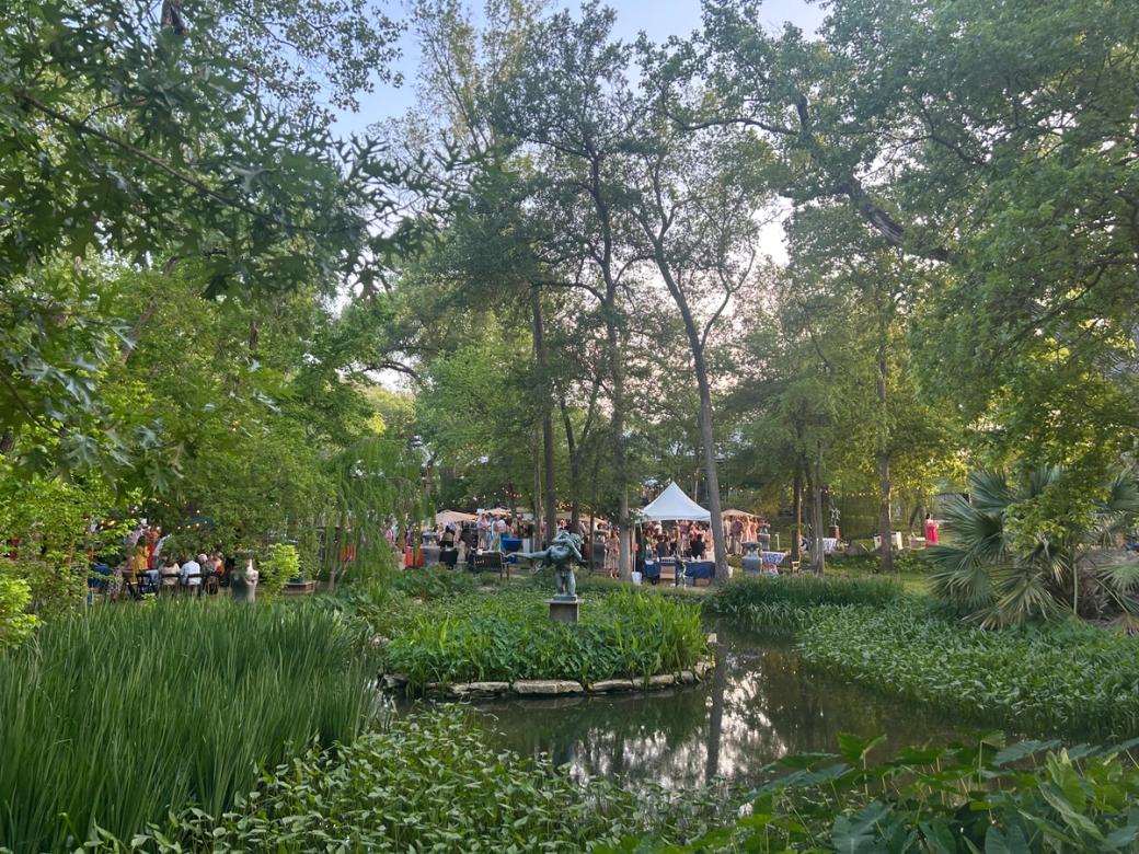 A green garden with a statue in the middle. 