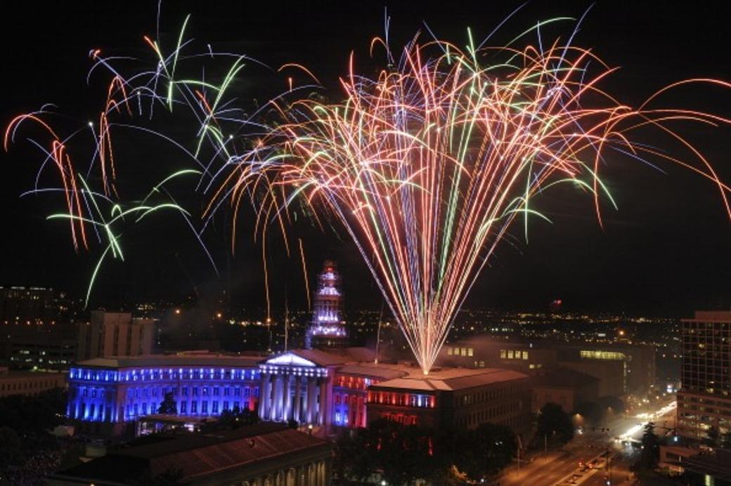 Bright fireworks shoot up from Denver’s City and County Building. 