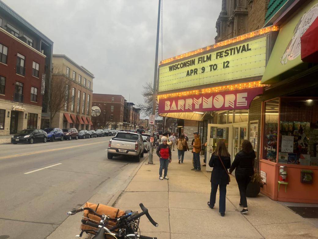 The sidewalk outside a theater marquee.