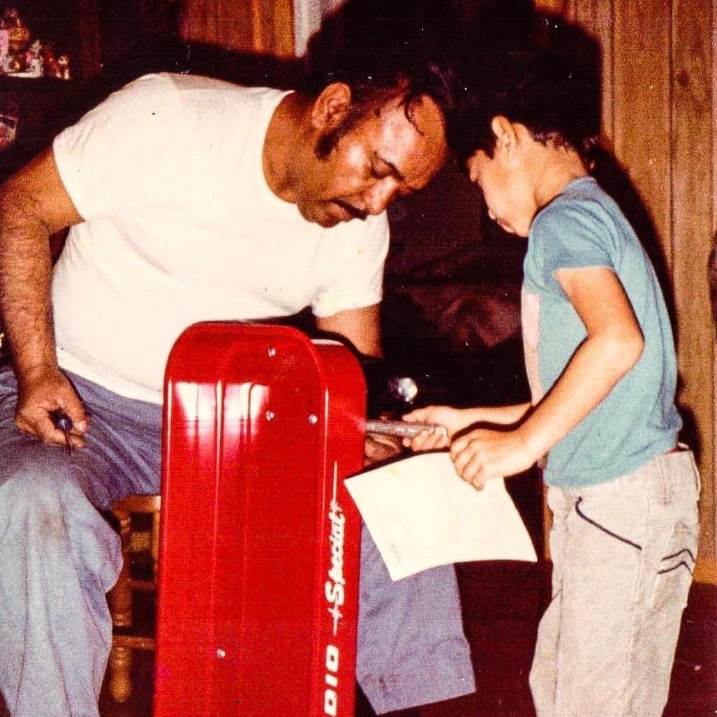 Juan Salazar and his Dad playing with a red toy.
