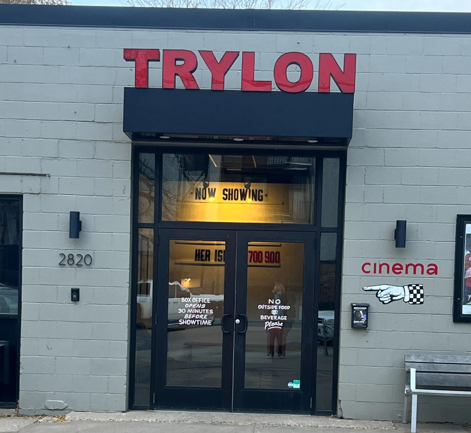 A front door. A sign reads "Trylon" above it