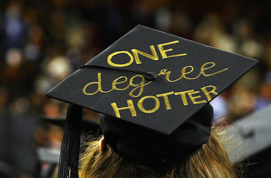 Some graduation caps playfully promote the graduation celebration, like this one. Others push back against the dominant narrative. (Boston Globe/Getty)