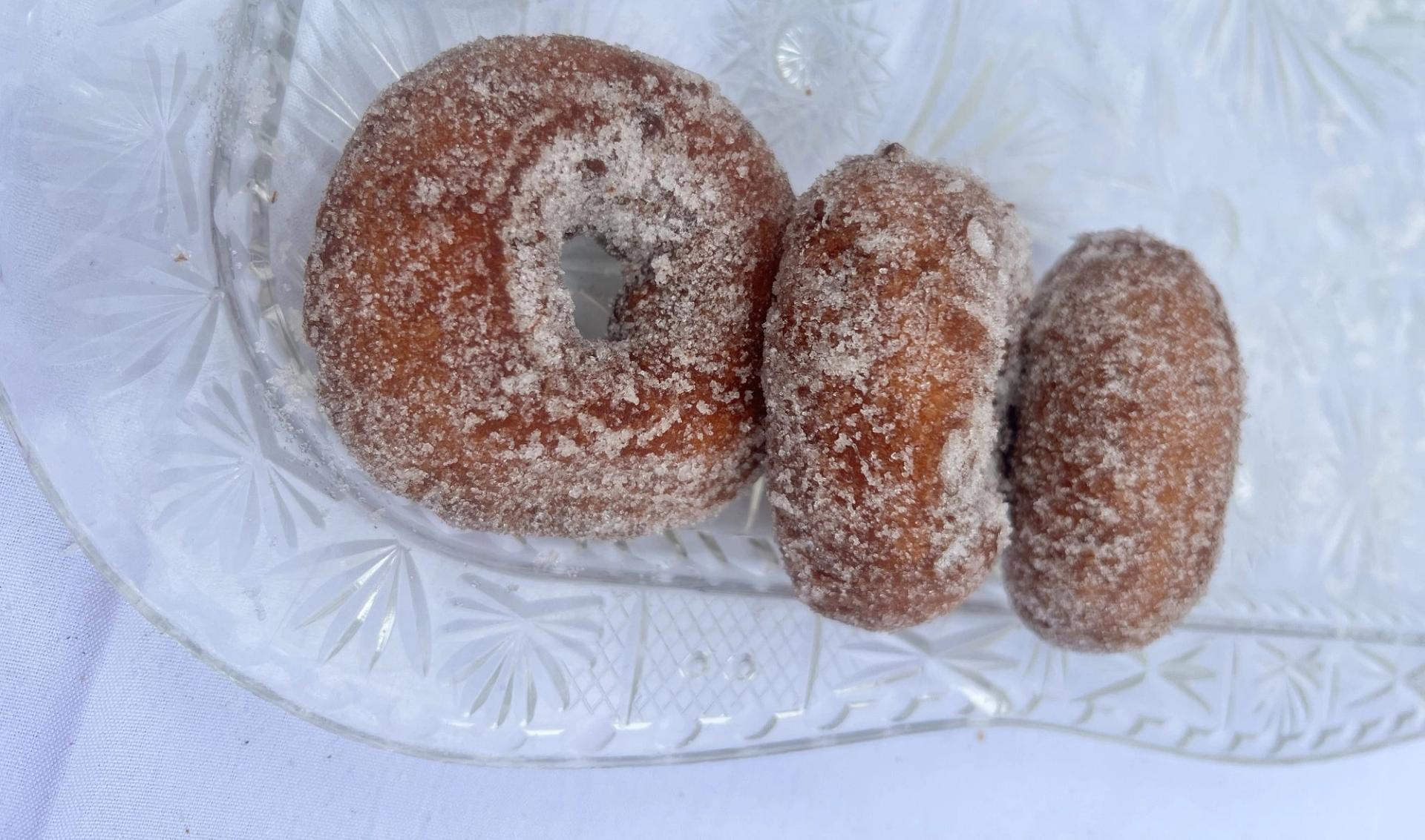 Three powdered donuts on a plate