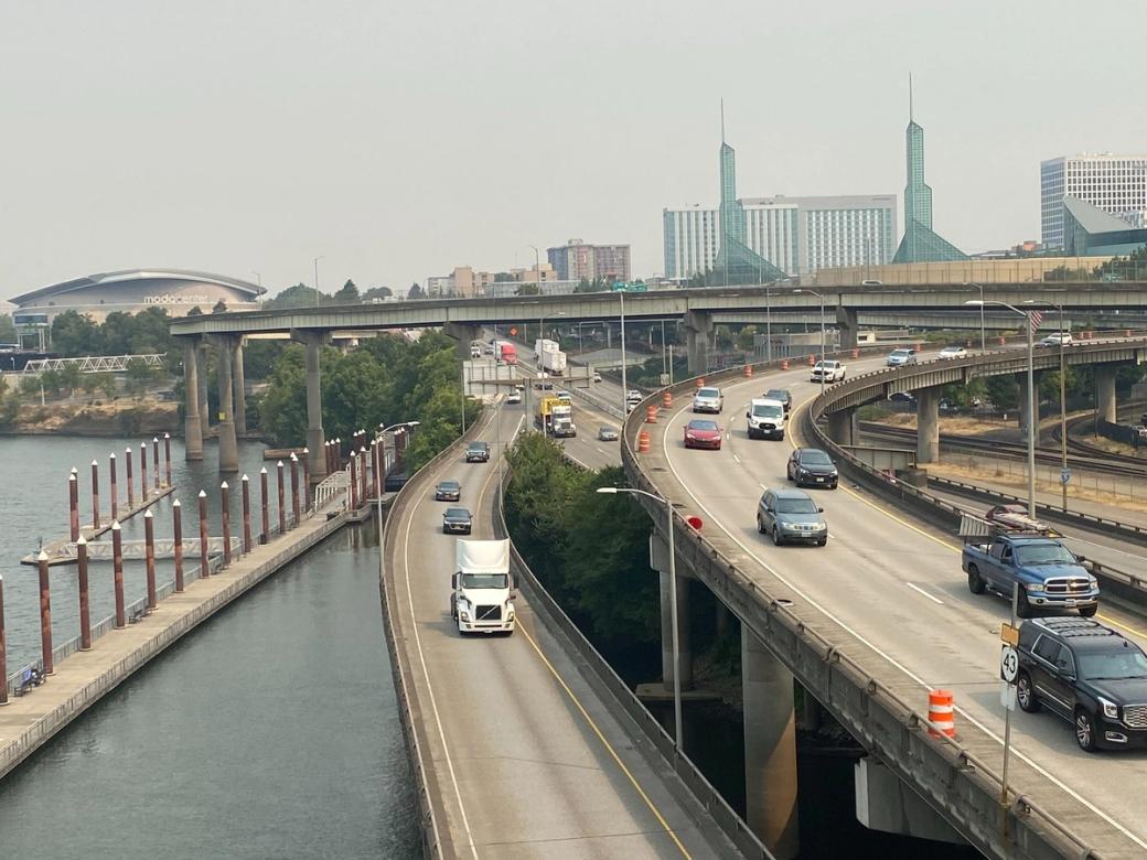 I-5 highway lanes as I-84 merges in along the Willamette River, Moda Center in the background