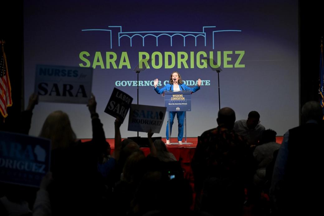 Governor candidate and current Lt.Gov. Sara Rodriguez speaks on a red stage during Wisconsin Democrats 2026 Convention on June 14, 2026 in Madison, Wisconsin.  Behind her the screen reads "Sara Rodriguez Governor Candidate."