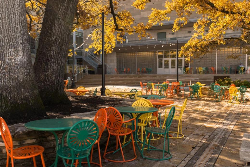 A terrace with orange, yellow, and green chairs.