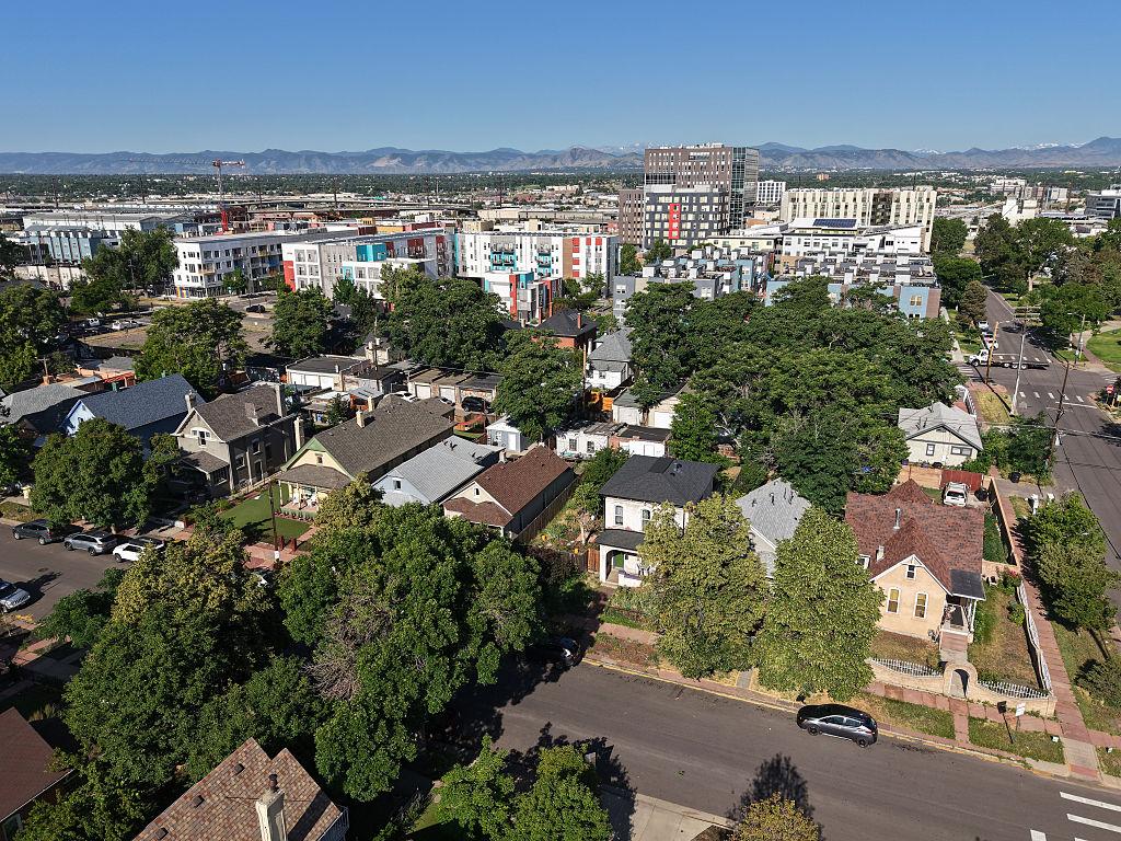 Aerial view of houses and neighborhoods in Denver with mountains in background