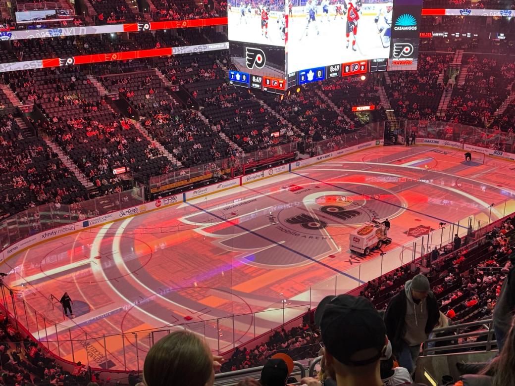 The Flyers' home rink is lit up with orange at a game in January.