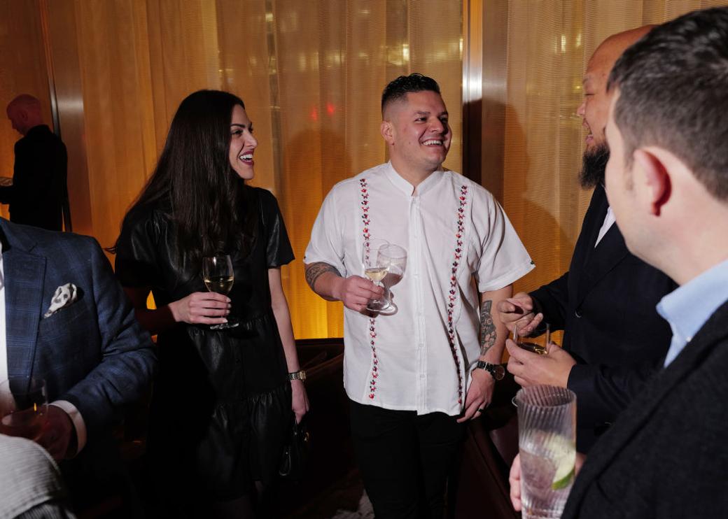 Two people smile with drinks in a conversation