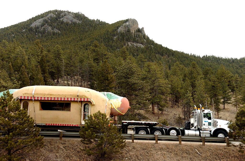 The giant coney island hot dog stand being hauled on a semi-truck from Denver to its new home in Bailey