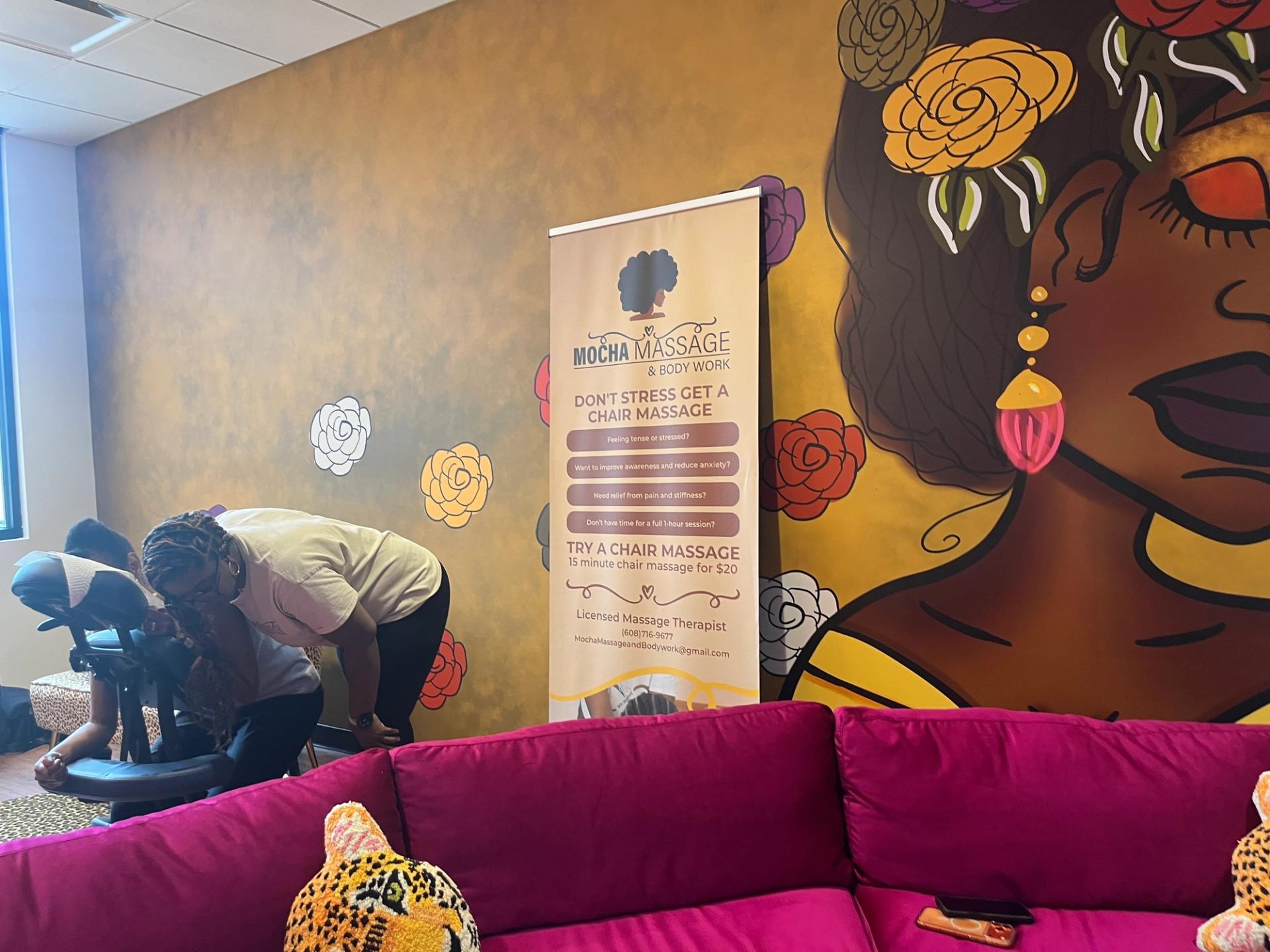 A room with a purple couch and yellow walls.