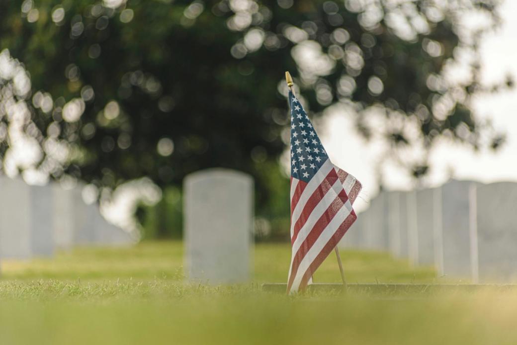 American flag in soil of cemetery