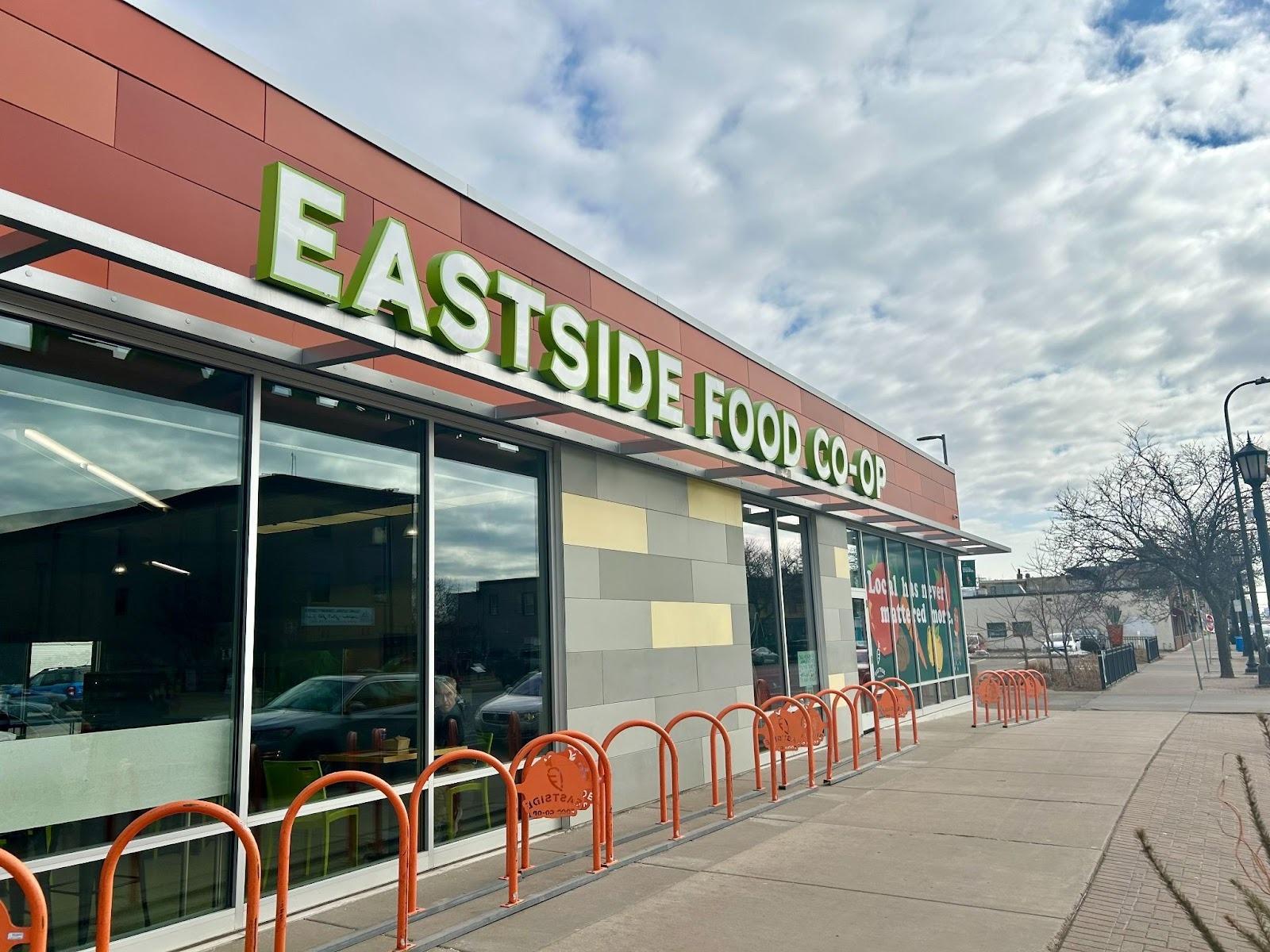 A building with red bike racks out front. The sign on it reads "eastside food co-op"