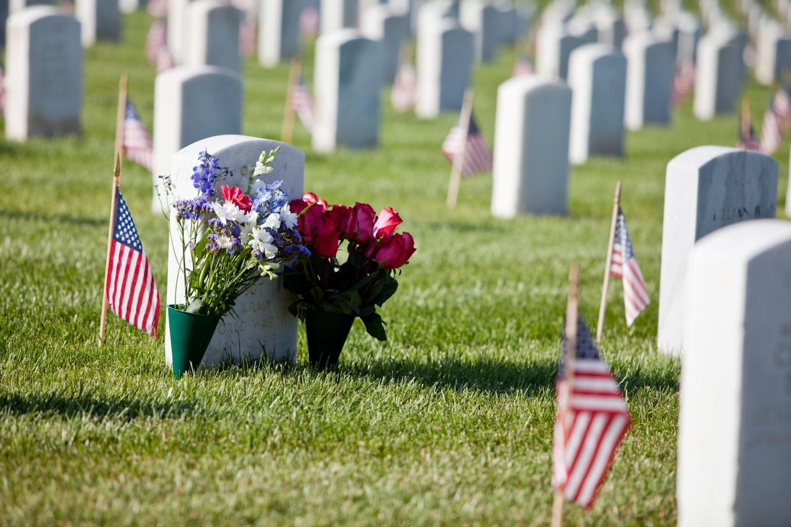 Flowers and a U.S. flag decorate a soldier’s grave.