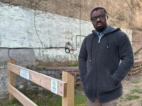 Dominique Johnson stands in a vacant lot next to his home