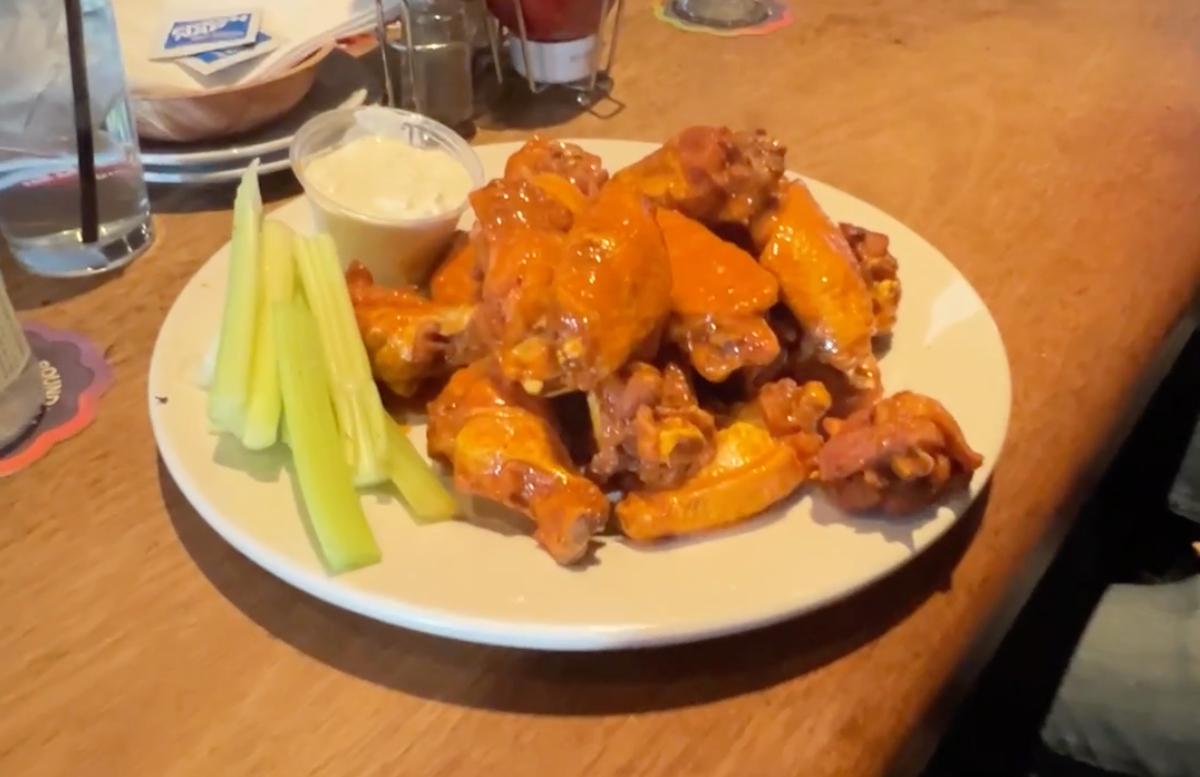 Orange chicken wings on a plate with celery
