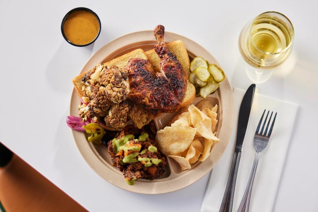 A plate with chicken and potato chips on it.