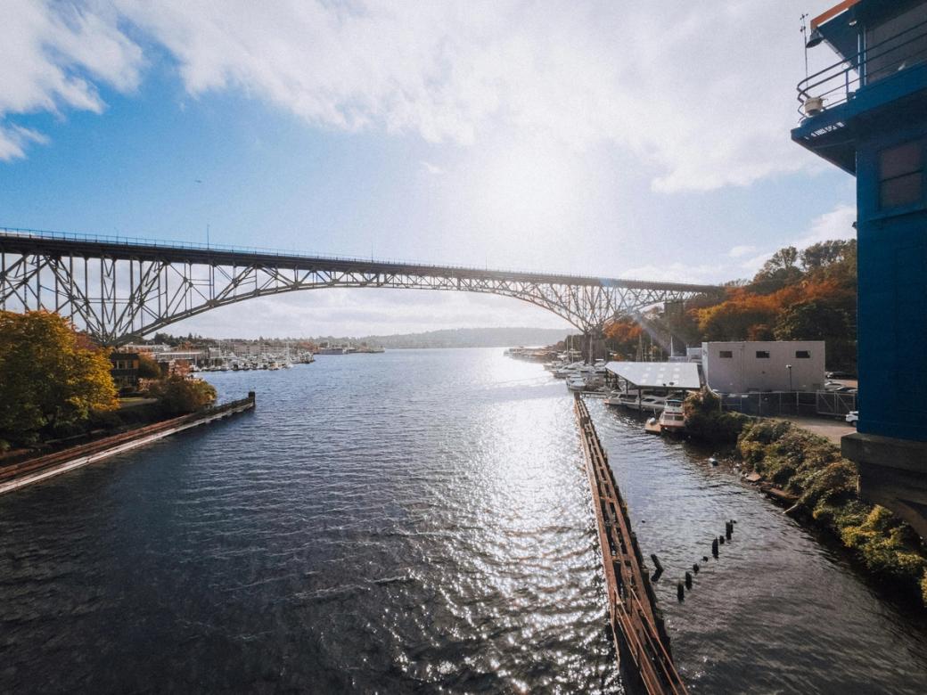 A sunny fall day with blue skies and yellow and orange tree leaves with a wide-lens view over the Lake Washington ship canal.