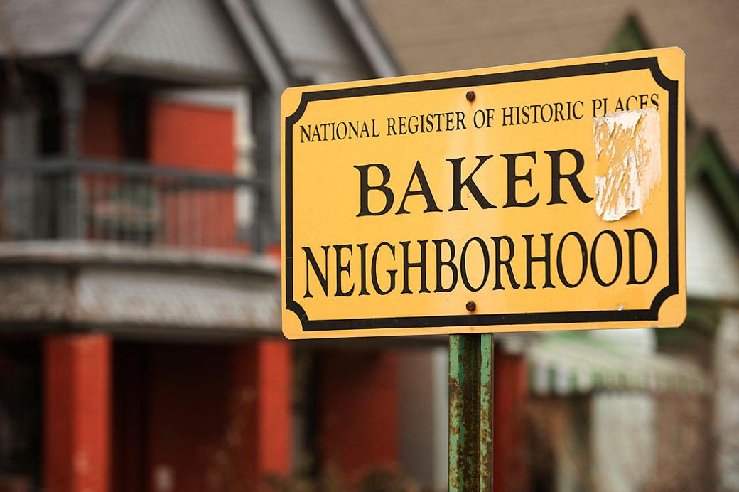 yellow Baker Neighborhood sign in Denver with historic homes in the background