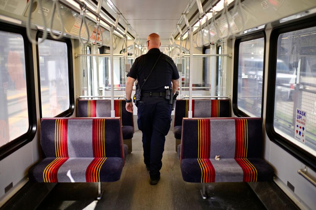 Denver police officer walks inside the RTD train