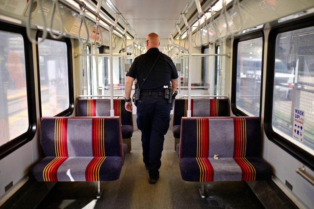 Denver police officer walks inside the RTD train