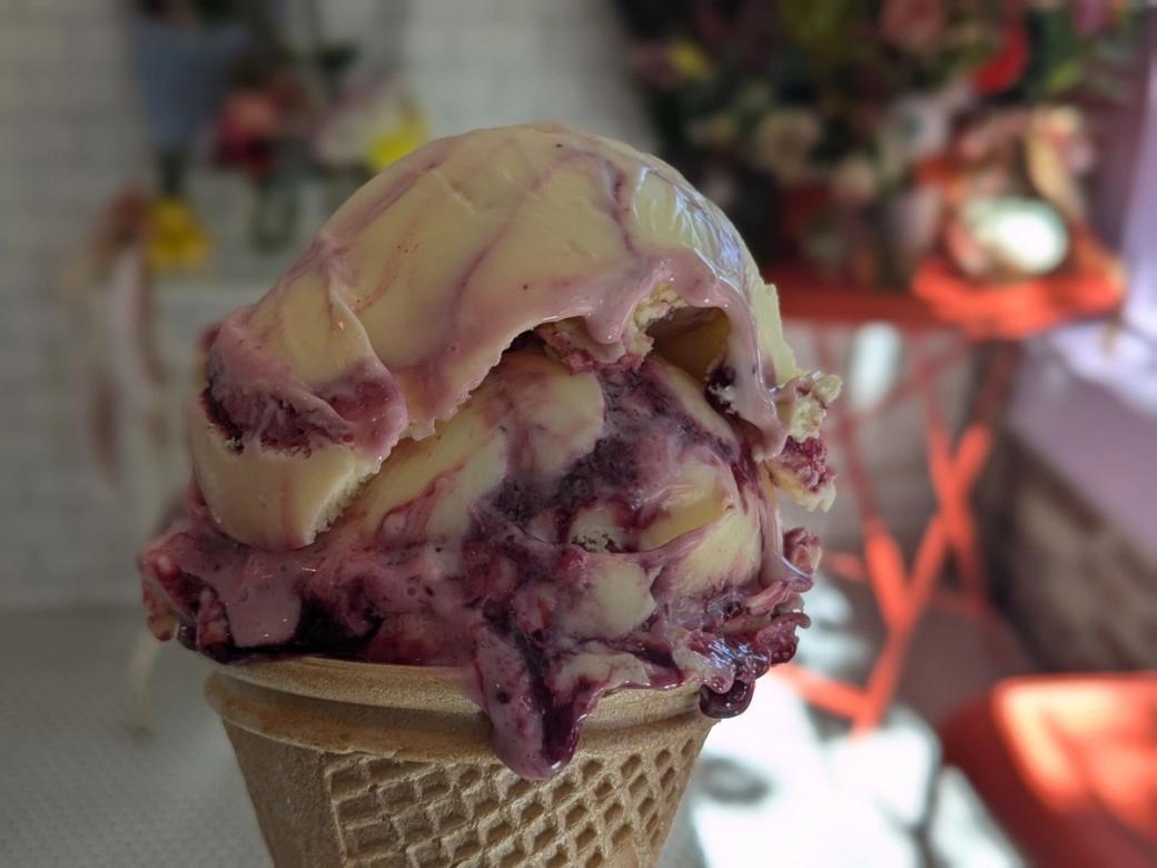 A berry-flavored ice cream in a cone.