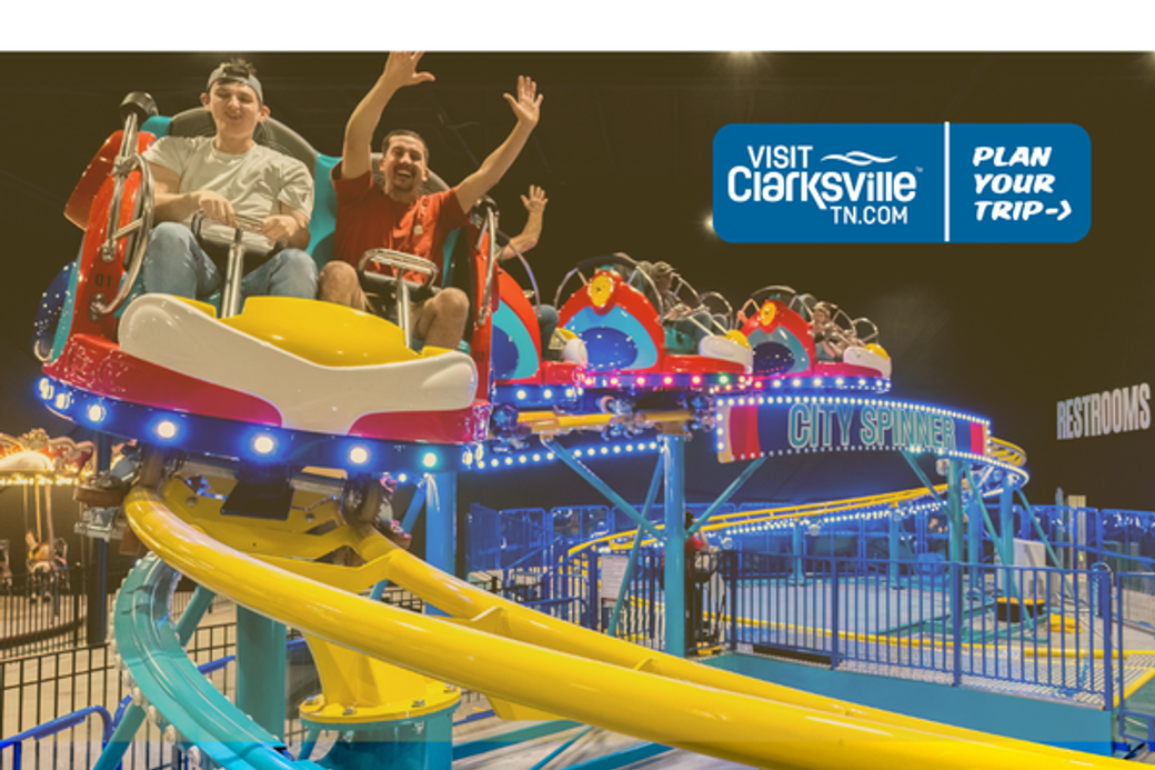 Two people enjoy a colorful amusement park ride called "City Spinner" with vibrant lights. They wave their arms excitedly. A "Visit Clarksville, TN" ad is visible.