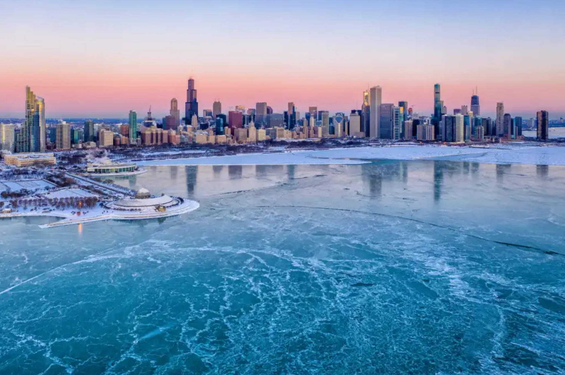 Aerial View of Chicago skyline at sunrise, frozen Lake Michigan and sea smoke.