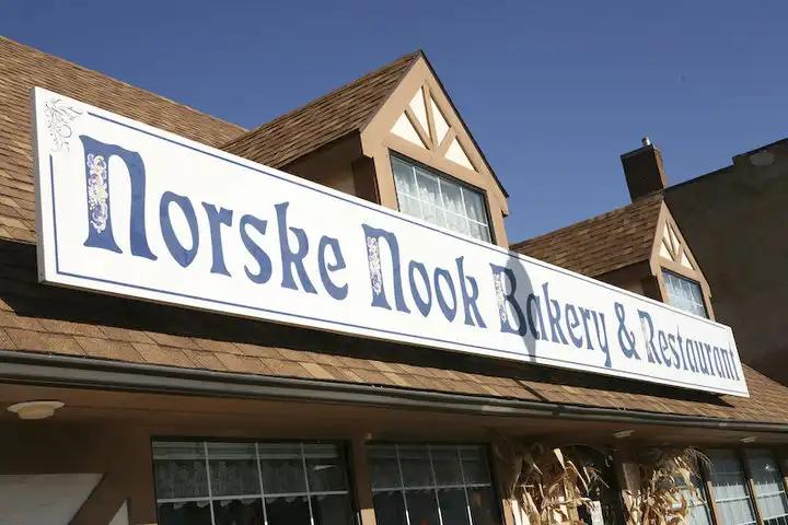 A white sign outside a brown building.