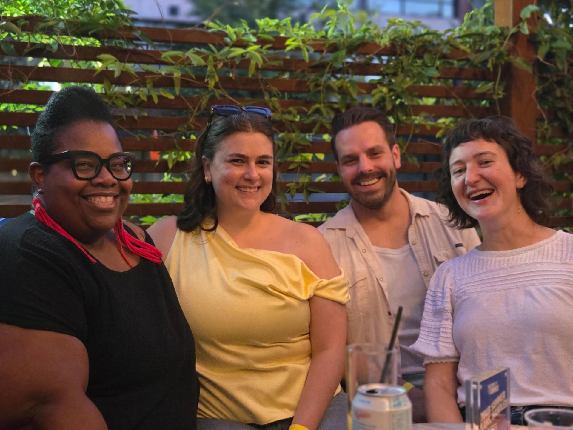 Four people smiling.