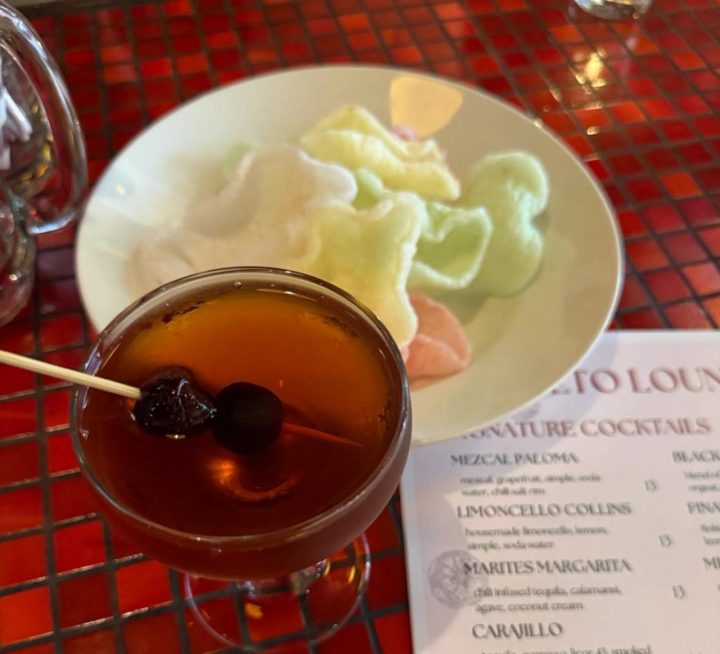 A dark cocktail on a red tile countertop.