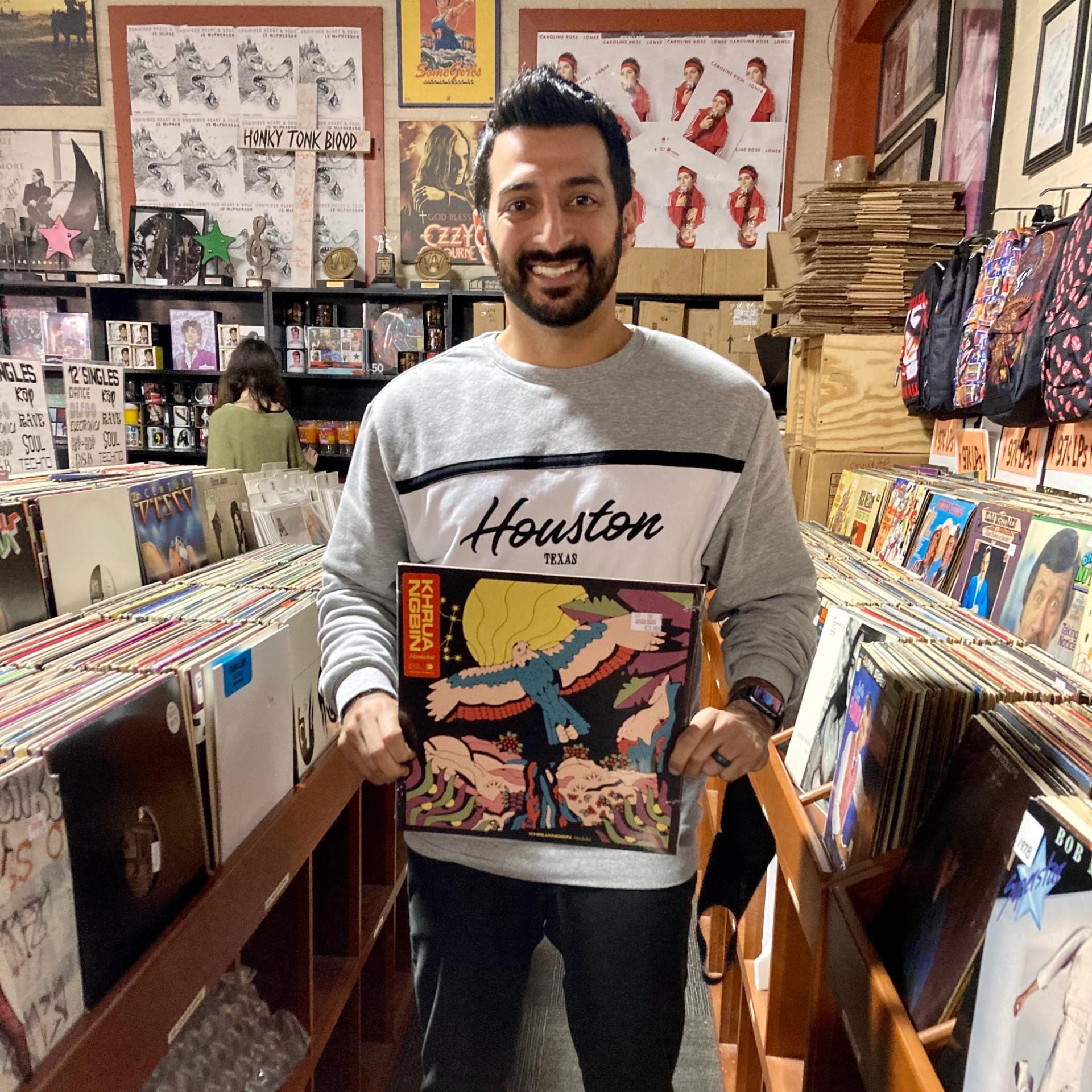City Cast Houston Host Raheel Ramzanali holds a Khruangbin record at Cactus Music. (Provided by Raheel Ramzanali)