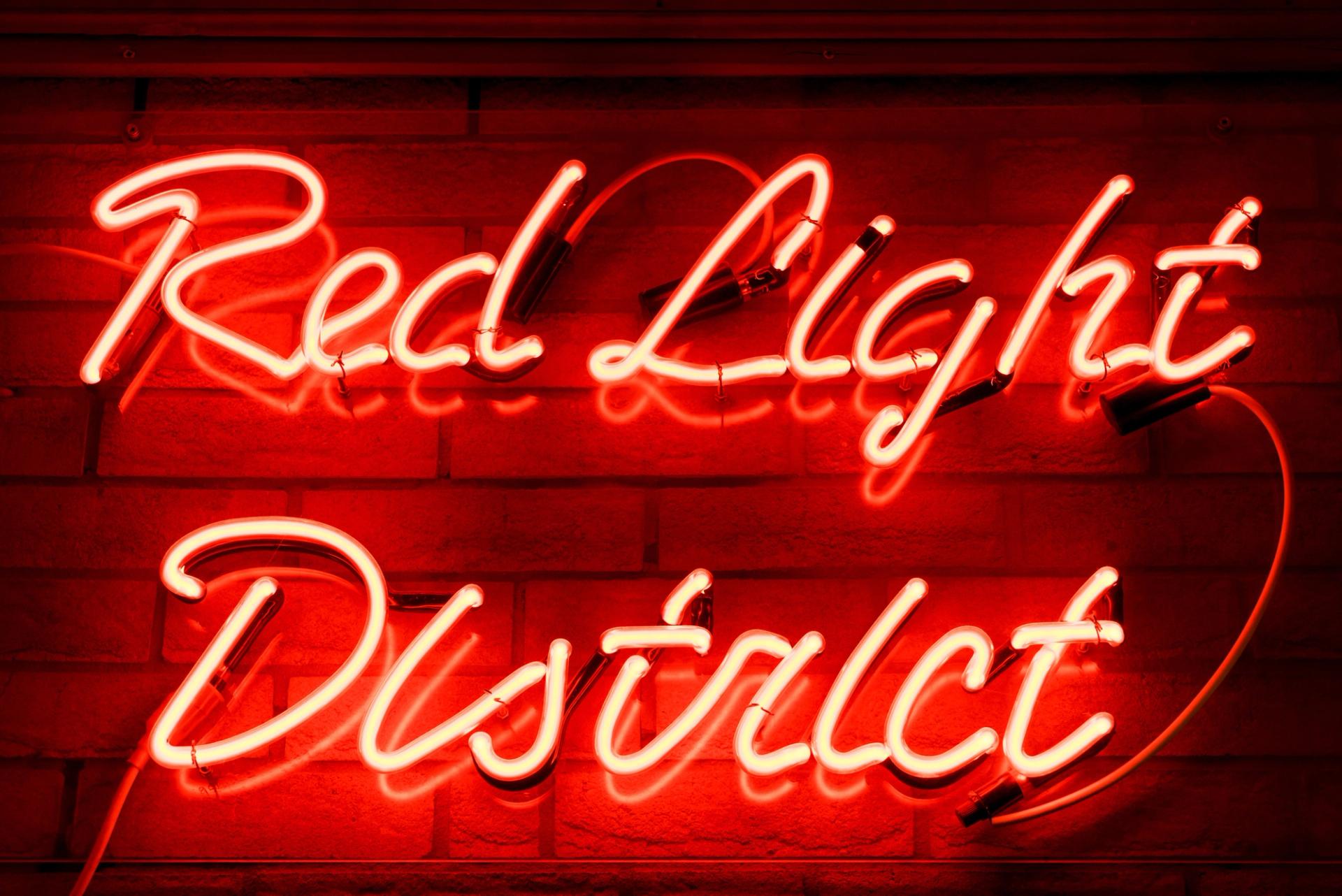 Photo of a sign that says "red light district" in red neon.
