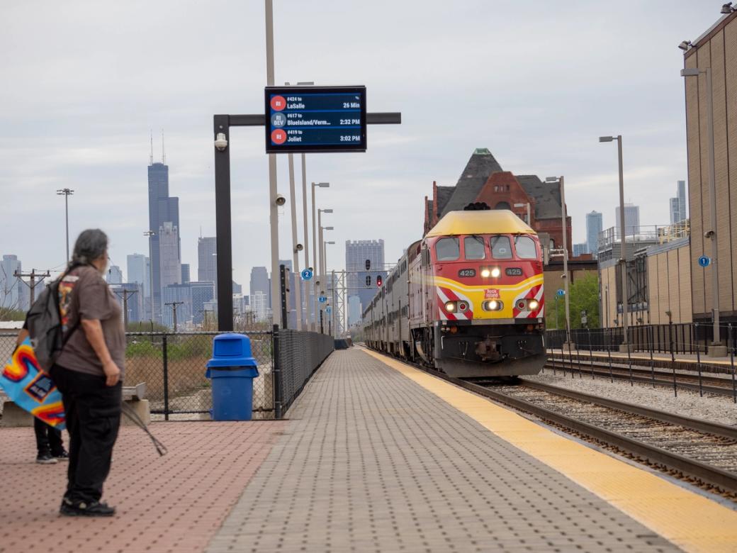 People waiting for a train as it arrives to pick them up