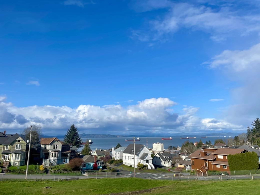 Blue sky above the river in background, buildings in foreground
