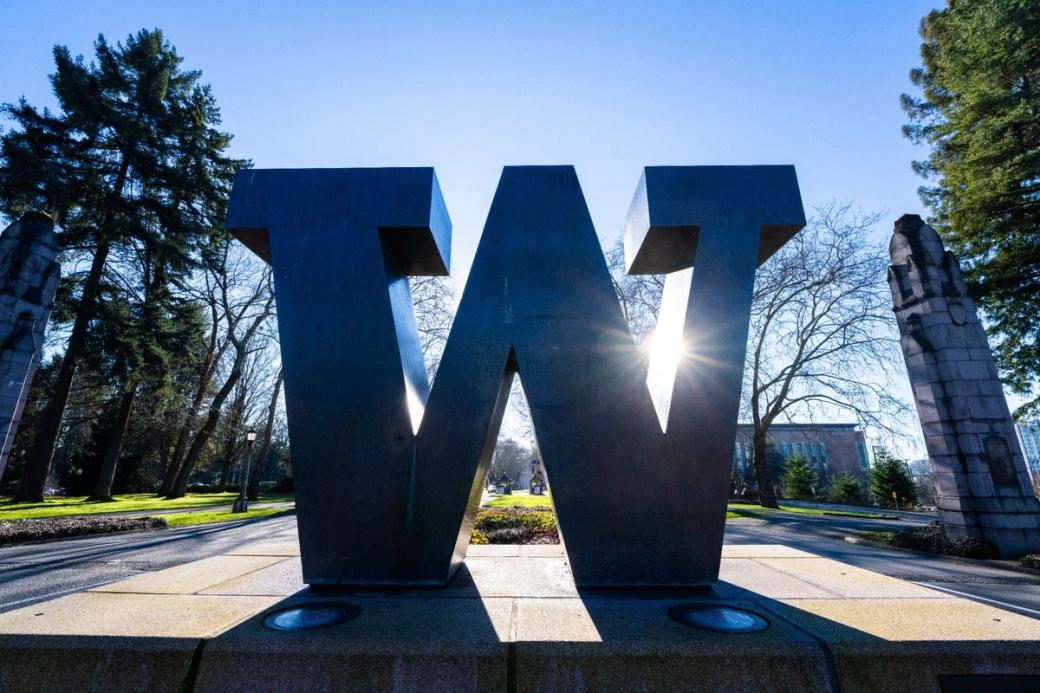 An image of the W at the UW campus with the sun gleaming on it from behind