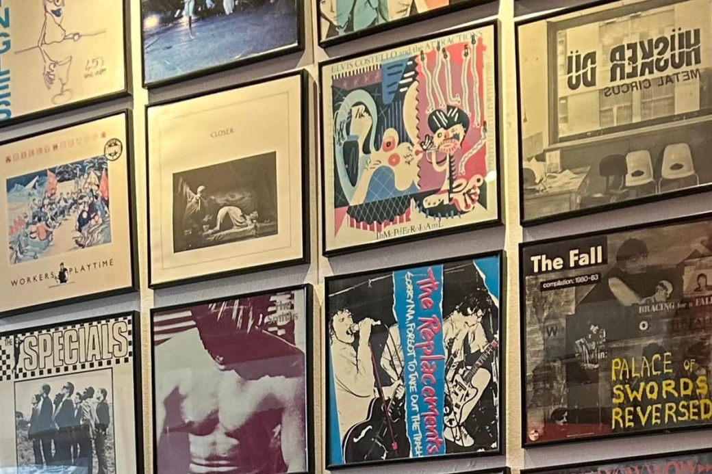 A wall with framed vinyl album covers.