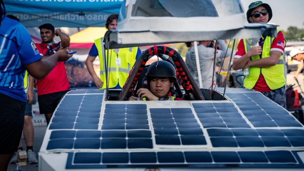 A driver in a race car covered in solar panels.