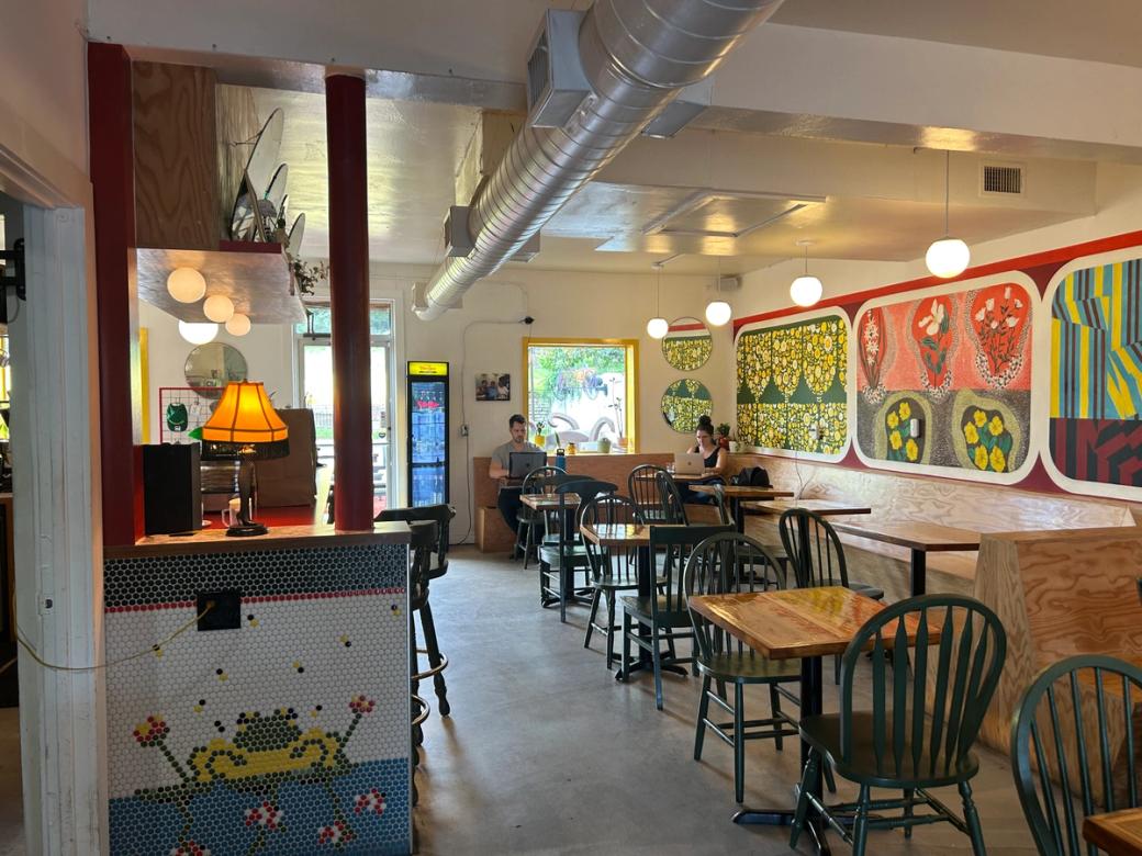 A colorful coffee shop with murals on the walls. 