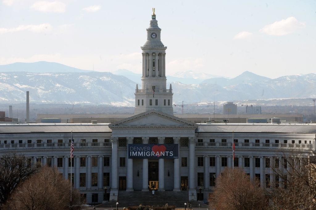 A banner at the capitol reads "DENVER LOVES IMMIGRANTS"