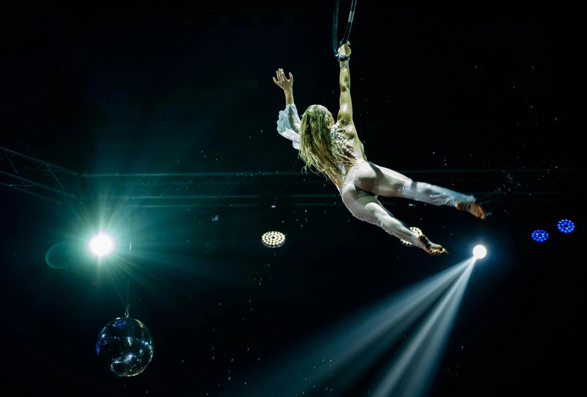 A woman suspended in air by a rope