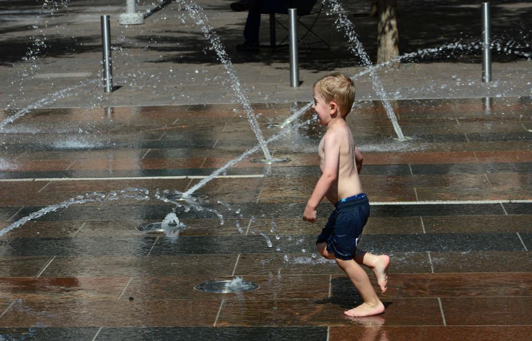 A child plays in a fountain at Union Station on a hot day.