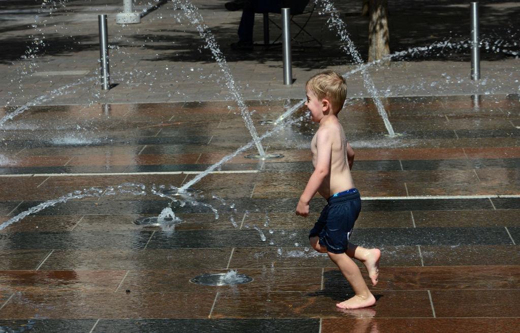 A child plays in a fountain at Union Station on a hot day.