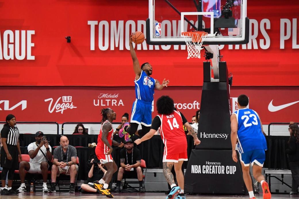Basketball players in red uniforms and blue uniforms shoot hoops on a court.