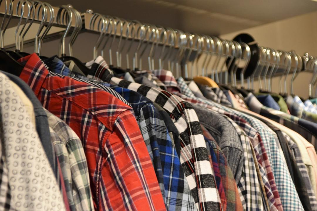 Shirts in assorted colors hanging on a metal rod
